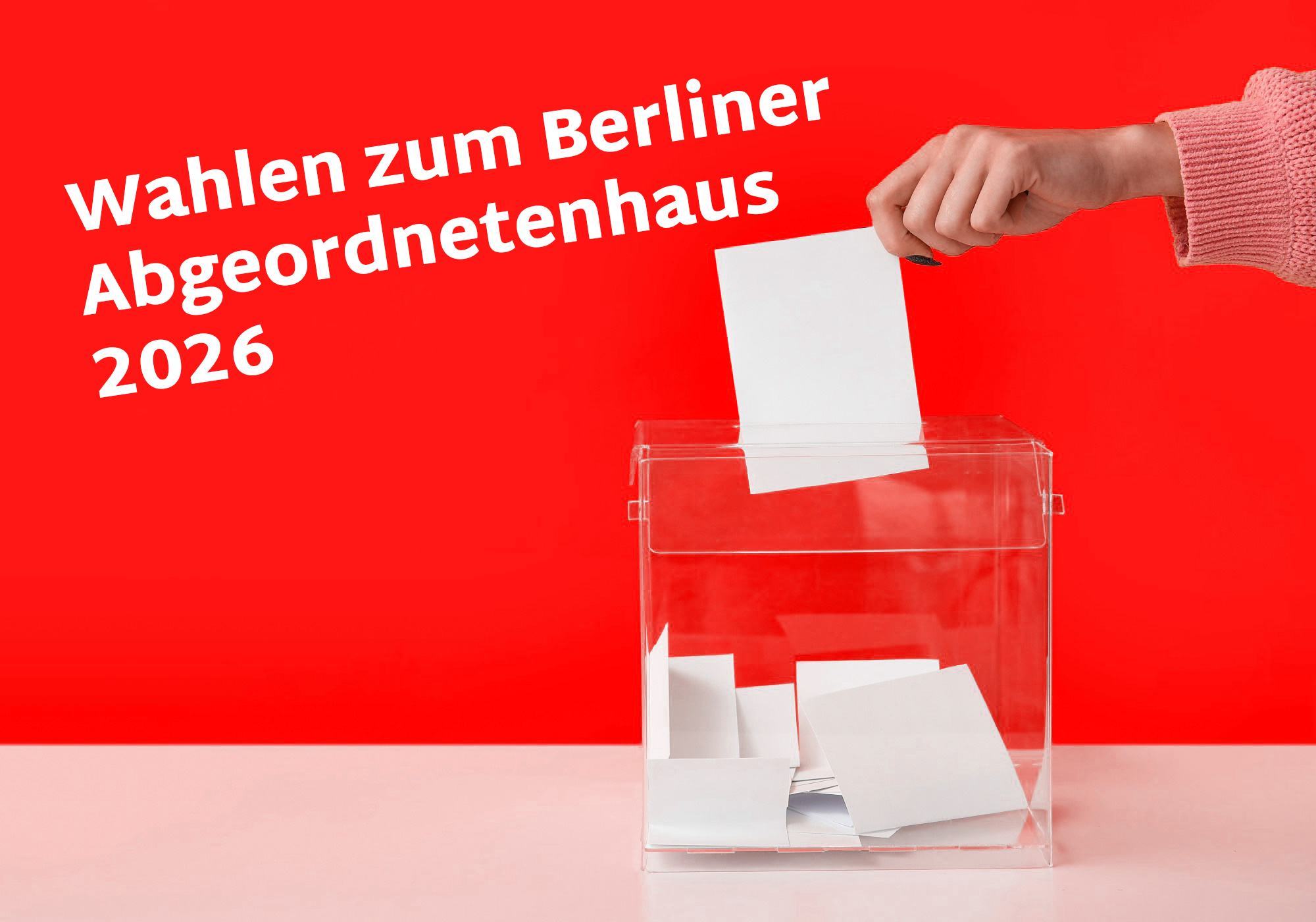 Ein Wahlzettel wird von einer Hand in eine transparente Box eingeworfen.